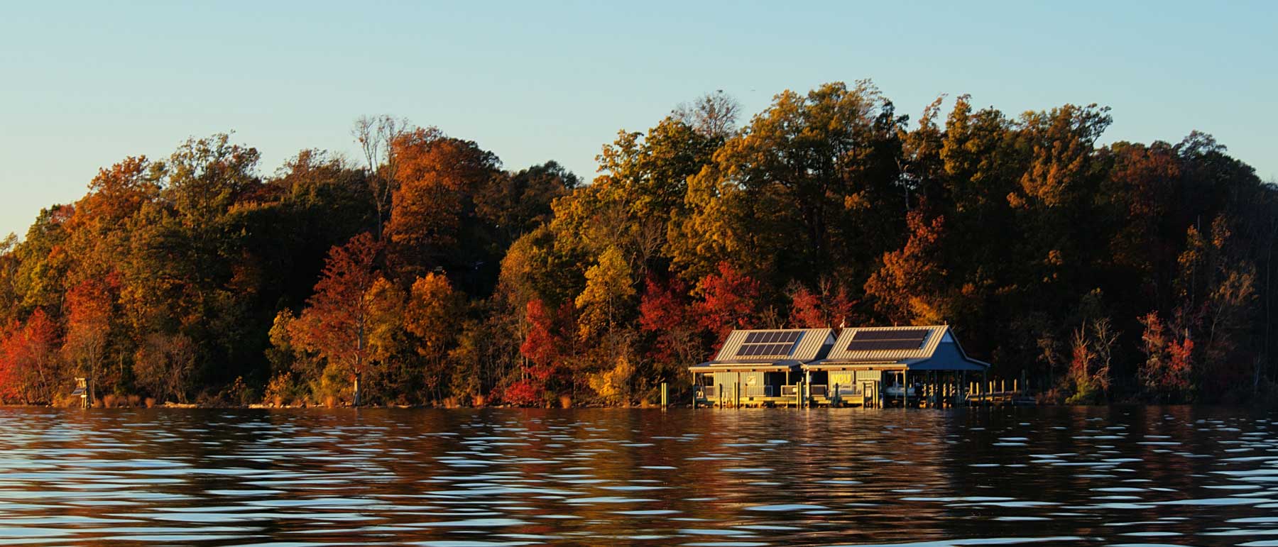 the rice rivers center boathouse and pier sitting on the james river with surrounding woodlands