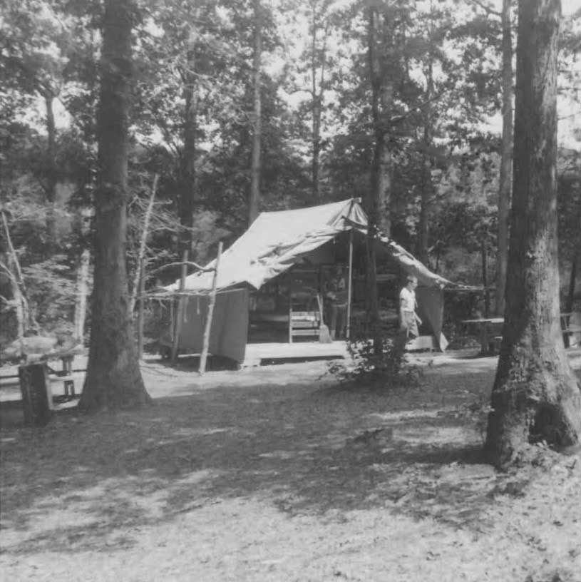 historical picture of camp weyanoke with a man coming out of a tent