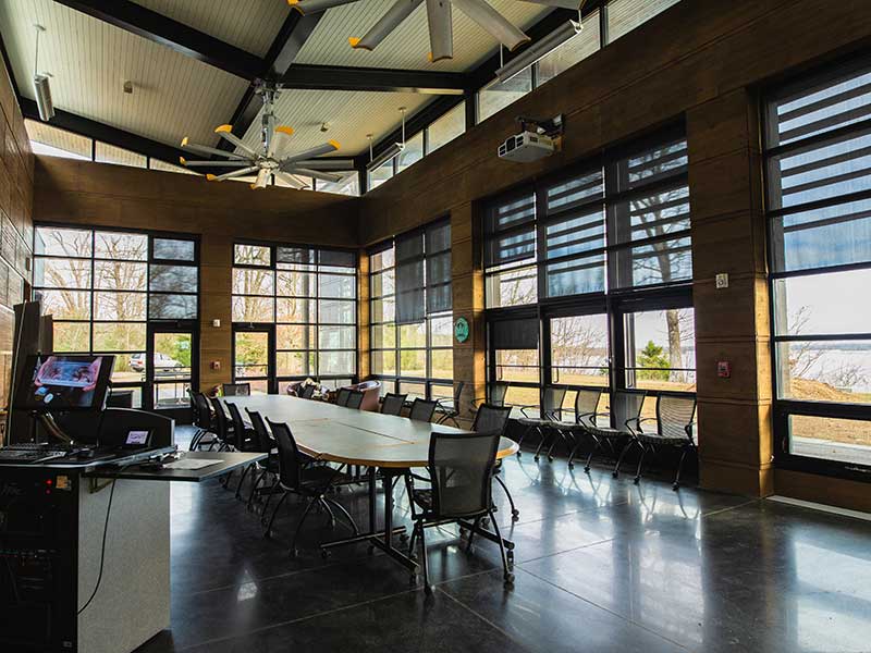 a sunny conference room with lots of windows and a long work table