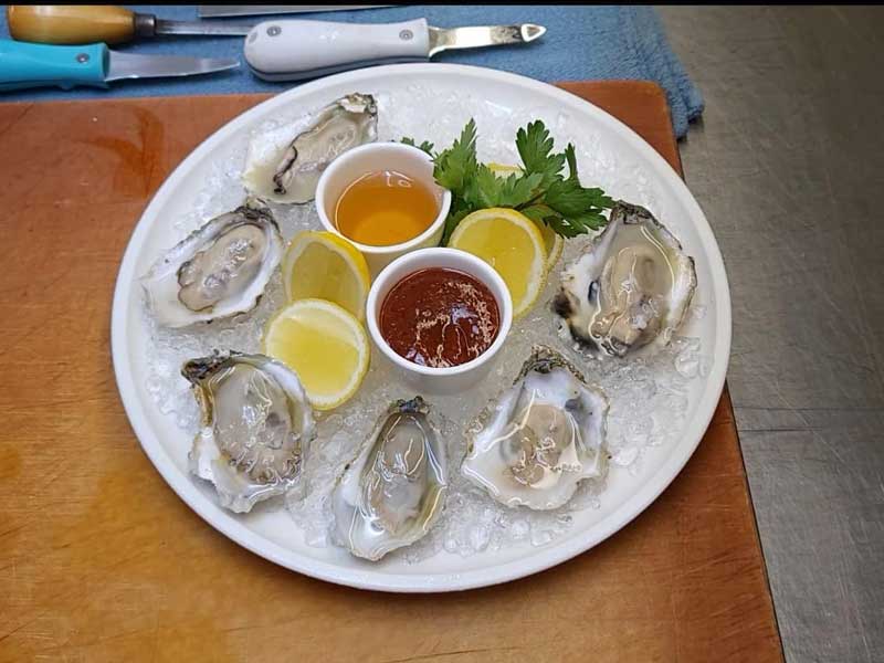 a plate of oysters on a table in a restaurant