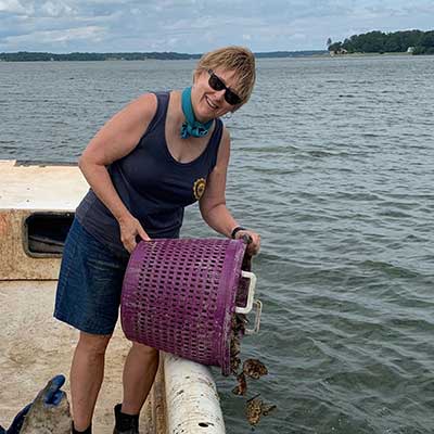 cindy andrews dumping oyster into the river